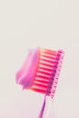 Pink plastic toothbrush with a white toothpaste on an isolated background Royalty Free Stock Photo