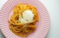 pink plate of fresh spaghetti with tomato sauce and parmesan cheese Royalty Free Stock Photo