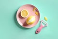 Pink plate with lemon and zester on color background