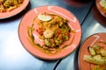 Pink plates with traditional Spanish dish Paella with meat, rice , seafood