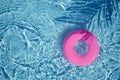 Pink pool float ring floating in a refreshing blue swimming pool. Top view Royalty Free Stock Photo