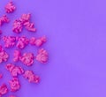 Pink popcorn on purple paper background. Fashion pop art style. Top view.