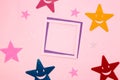 pink-purple frame as copy space on a pink background, colorful stars around the frame, creative art minimal concept Royalty Free Stock Photo