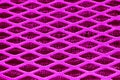 Pink Purple metal lattice lozenge rhombus close-up, under a fine metal grid.