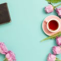 Pink purple rose flowers and diary note, black tea on mint green background