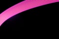 Pink and purple shining neon curved line of light as arc with smooth stripes on black background