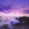 Pink and Purple Sunset Over Misty Rocks in the Sea