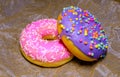 Pink and purple sweet donuts with icing and sugar decoration. Object concept. Side view. Lying flat. Food concept. Macro concept.