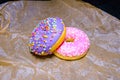 Pink and purple sweet donuts with icing and sugar decoration. Object concept. Side view. Lying flat. Food concept. Macro concept.