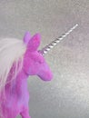 Pink and purple unicorn toy figure on a silver background