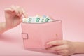 Pink purse and Euro banknotes in Female hands on pink background. Business Concept and Instagram Royalty Free Stock Photo