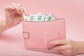 Pink purse and Euro banknotes in Female hands on pink background. Business Concept and Instagram Royalty Free Stock Photo