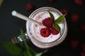 Pink raspberry smoothie in a mason jar with straws on a black background Royalty Free Stock Photo