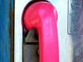 Pink receiver of old coin operated street phone Royalty Free Stock Photo