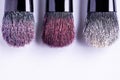 Pink, red and golden powder eye shadows with glitter on brushes on white background. Makeup concept, top view of glitters on the Royalty Free Stock Photo