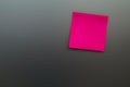 Pink reminder sticky note on stainless board, empty space for text