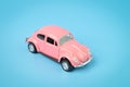 Pink retro car toy model isolated on a blue background Royalty Free Stock Photo