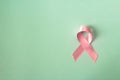 Pink ribbon breast cancer symbol on pastel background.