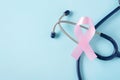 Pink ribbon with stethoscope on blue background, breast cancer awareness month Royalty Free Stock Photo