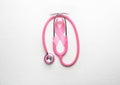 Pink ribbon and stethoscope on light background. Breast cancer awareness concept Royalty Free Stock Photo