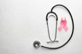Pink ribbon and stethoscope on light background. Breast cancer awareness concept Royalty Free Stock Photo