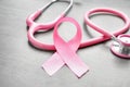 Pink ribbon and stethoscope on light background, closeup. Breast cancer awareness concept Royalty Free Stock Photo