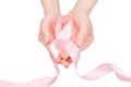 Pink ribbon in woman hands isolated on white. Breast Cancer Awareness ribbon Royalty Free Stock Photo