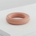 Pink Ring Shaped Electronic Gadget on White Minimalist Platform Still Life Royalty Free Stock Photo