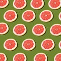 Pink ripe grapefruit slices on the green background pattern Royalty Free Stock Photo