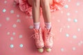 pink roller skates on pink background with white polka dots