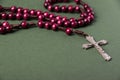 Pink Rosary on a green background.