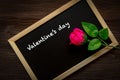 Pink Rose on the chalkboard for written Valentine Day. Old wood background