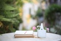 Pink rose and daisy flowers in ceramic basket with notebooks