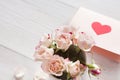 Pink rose flowers bouquet and handmade greeting card on white rustic wood Royalty Free Stock Photo