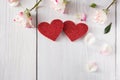 Pink rose flowers petals and handmade wooden glitter hearts on white rustic wood Royalty Free Stock Photo