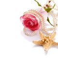 Pink rose with a pearl beads and a starfish. Royalty Free Stock Photo