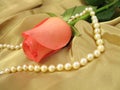 Pink rose and pearls on gold satin Royalty Free Stock Photo