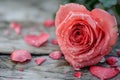 a pink rose in the shape of a heart on a wooden table