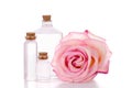 Pink rose and three glass bottles with transparent liquid Royalty Free Stock Photo