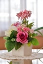 A pink rose vase by the window