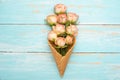 Pink roses in a cone with ice cream on a blue wooden background, concept gift for the beloved festive background, anniversary, Royalty Free Stock Photo