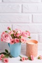 Pink roses flowers in blue cup and burning candle against whit Royalty Free Stock Photo