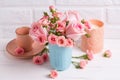 Pink roses flowers in blue cup, burning candle and little cup for coffee Royalty Free Stock Photo