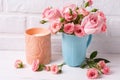 Pink roses flowers in blue cup and burning candle Royalty Free Stock Photo