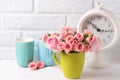 Pink roses flowers, clock and colorful green and blue cups agai Royalty Free Stock Photo