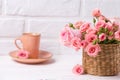 Pink roses flowers and cup of coffee against white brick wall Royalty Free Stock Photo