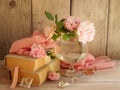 Pink roses in glass vase, old books, pink silk fabric on wooden table.Beautiful romantic shebby composition