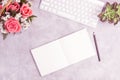 Pink roses on grey table with white keyboard and open notebook Royalty Free Stock Photo