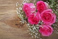 Pink Roses and Gypsophila on Wooden Background