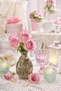 Pink roses in vase on the table in shabby chic style interior